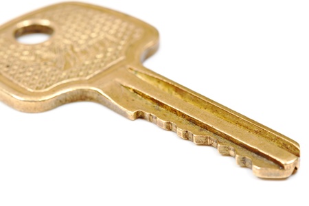 Yellow metallic key isolated on whiteの写真素材