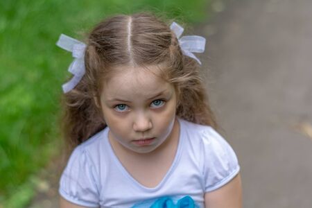 Sad look of little girl outdoor.