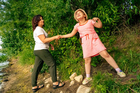 Happy loving woman with her daughter in nature on a sunny summer day.の写真素材