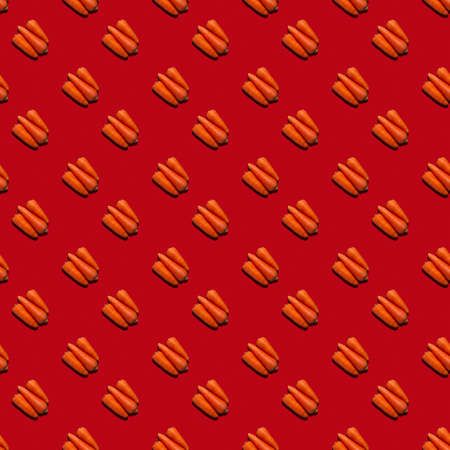 Seamless pattern from fresh juicy carrots on a uniform colored background.