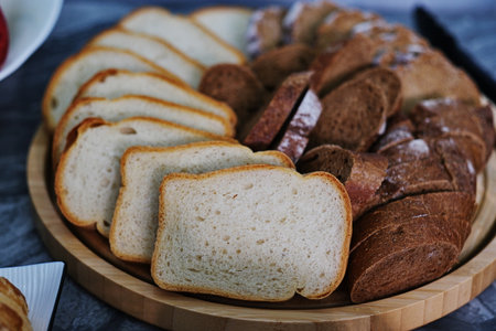 Slices of bread on a wooden plate. Selective focus.