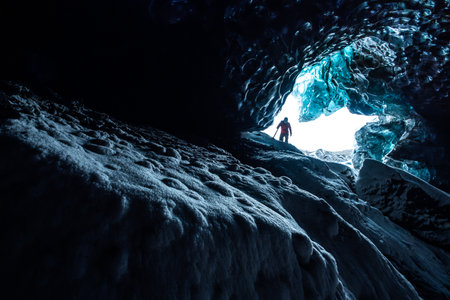 Adventurer discovering the inside of an ice cave in Icelandの写真素材