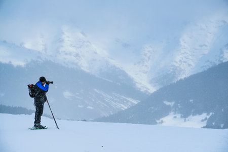 Man taking a photo in a snowfallの写真素材