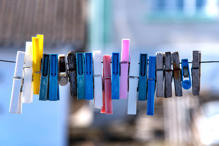 Colorful clothespin hanging on a rope. Plastic and wooden clothespins.