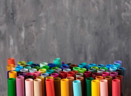 A set of colorful markers, with a place for copy space on grey background.