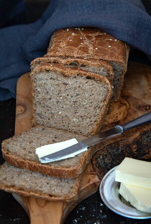 Homemade whole grain bread with with seeds. A piece of bread with butter.