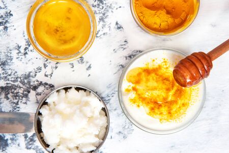 Natural face mask with turmeric powder, honey and yogurt. Natural cosmetics on a white background.の写真素材