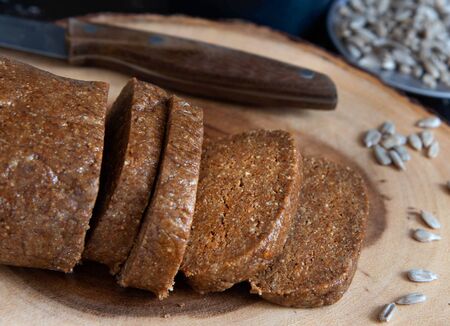 Homemade sunflower halva sliced on wooden background.