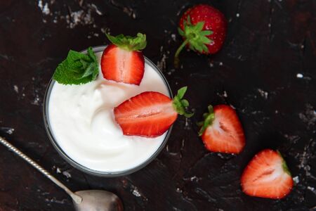 Bowl of Strawberries and sour cream on a black background. Healthy dessert.の写真素材