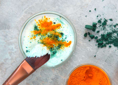Natural face mask with turmeric powder, spirulina and yogurt. Natural cosmetics on a white background.の写真素材