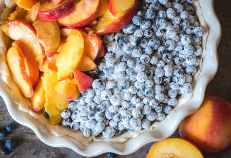 Raw tart filled with peaches and blueberries.の写真素材