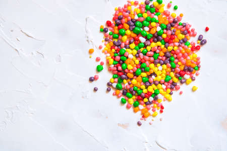 Rainbow colored candy nerds sprinkled on a white background.の写真素材