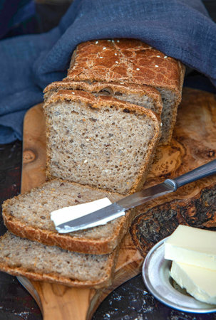 Homemade whole grain bread with with seeds. A piece of bread with butter.の写真素材