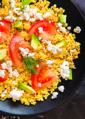 Fresh bulgur salad with tomatoes, avocado and feta cheese. Vegetarian salad with bulgur.の写真素材