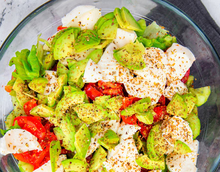 Healthy and diet food: salad with lettuce, avocado, tomatoes and mozzarella.の写真素材