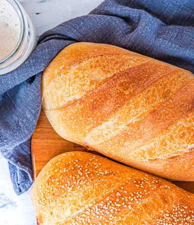 Rustic seeded baguettes small freshly baked bread rolls crusted sesame seedsの写真素材