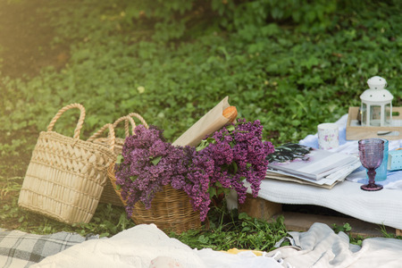 Picnic decorations, cannotier, flowers, fruits. Picnic at the park on the grass: tablecloth, basket, healthy food and accessories, top view. Happy holidays concept. Mothers day.の写真素材