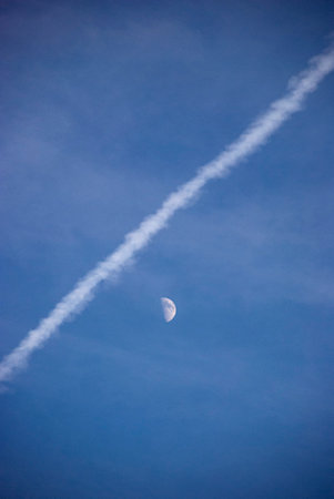 <p>Moon and contrails in the blue sky, closeup of photo</p>の写真素材