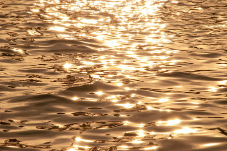 Sunset on the sea with waves and sun reflections. Abstract background.の写真素材