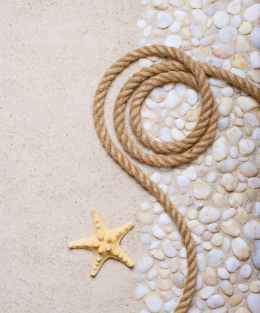 Rope and starfish on sea pebblesの写真素材