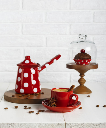 Red cup of coffee and coffee pot on the white tableの写真素材