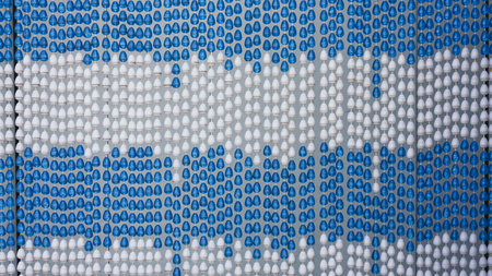Full frame of a plastic pearl door blind and curtain on a white barkground in blue and white...