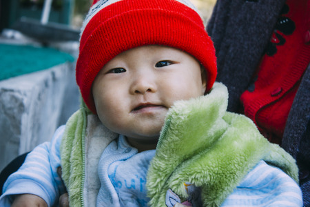 20 Oct,2014 Beijing China, A baby boy with red hat looking at cameraのeditorial素材