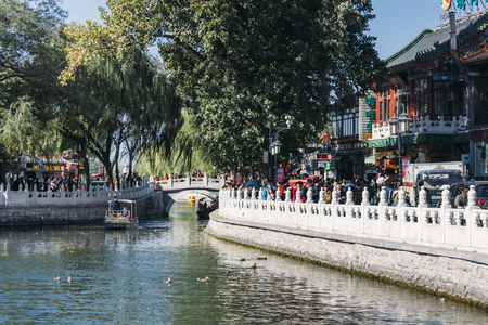 25,October 2014 -In Beijing ShiChaHai. Boats and bridge on Qianhai lake in Shichahai lake of Beijing China, many tourists  walking on sideのeditorial素材