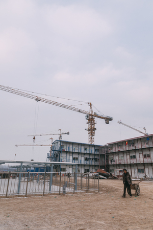 18 Dec,2014 Beijing. Work activity on a construction site in City with cranes and workers,building train stationのeditorial素材