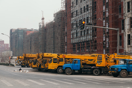 14,Dec,2014 - Beijing China,Yellow Crane trucks,on the road beside the construction site