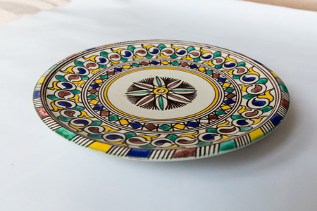 a white round plate with floral and line pattern on white background