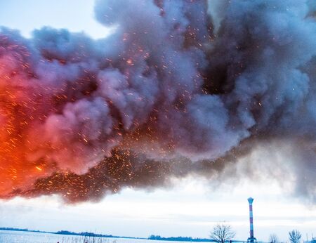 smoke from fire in front of lighthouseの写真素材