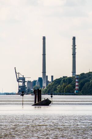power plant and lighthouse close to a riverの写真素材