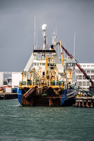huge fishtrawler discharging in portの写真素材