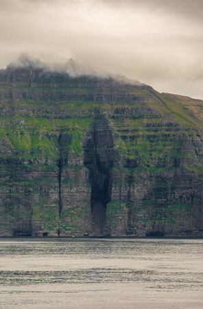 gap in the high cliffs above waterの写真素材