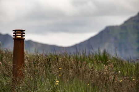 rusty lamp pole on a meadowの写真素材