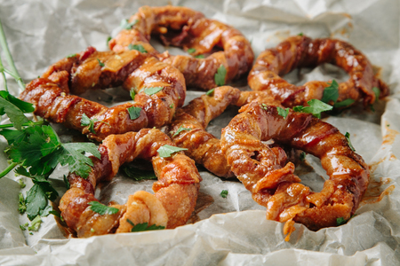 Onion rings seasoned with fresh parsley on parchment paperの写真素材