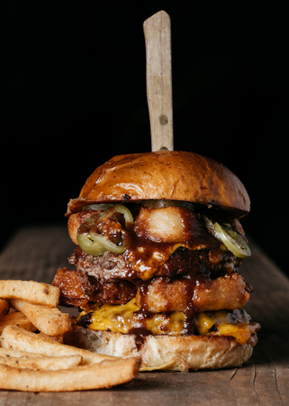 Double Meat Burger with fried onion rings, cheese and pickled jalapenosの写真素材