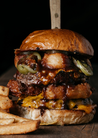 Double Meat Burger with fried onion rings, cheese and pickled jalapenosの写真素材