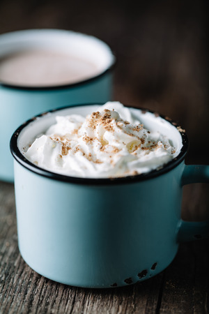 Delicious hot chocolate with whipped cream on rustic wooden backgroundの写真素材
