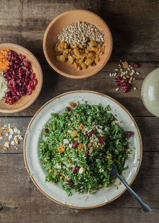 Chopped kale salad with carots, sliced toasted almonds, sunflower seeds, dried cranberries and lemon vinaigrette dressingの写真素材