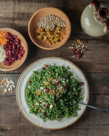 Chopped kale salad with carots, sliced toasted almonds, sunflower seeds, dried cranberries and lemon vinaigrette dressingの写真素材