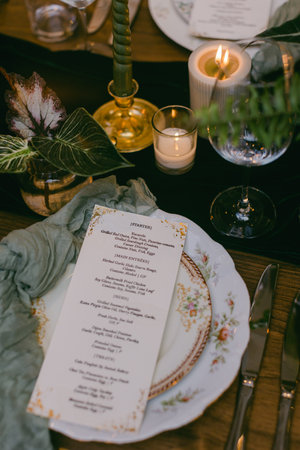 A beautifully arranged dining table features a detailed seasonal menu on fine china, surrounded by...