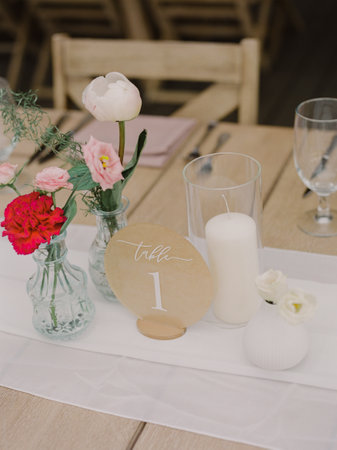 The table features delicate flowers in glass vases and a white candle, adding charm to the occasion.