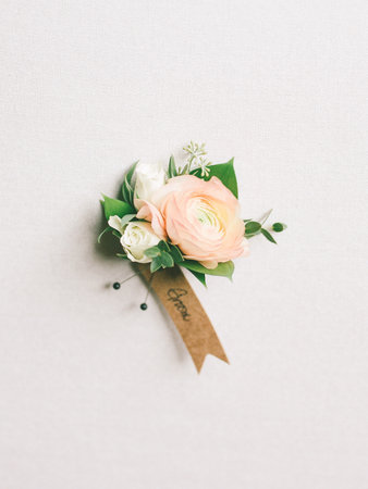 Beautiful flowers in soft colors are arranged on a wall, showcasing a delicate ribbon for a touch of...