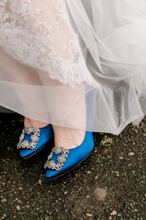 The bride's stunning blue shoes peek out from under her flowing wedding gown during the celebration.の写真素材