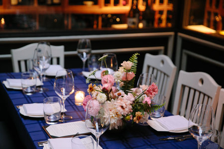 A beautifully arranged table featuring a floral centerpiece, glassware, and cutlery, set for a...