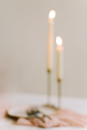 Soft candlelight casts a warm glow over a table adorned with delicate decor, creating a tranquil atmosphere.の写真素材