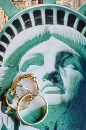Gold rings artfully placed by the Statue of Liberty blend themes of love and American symbolism.