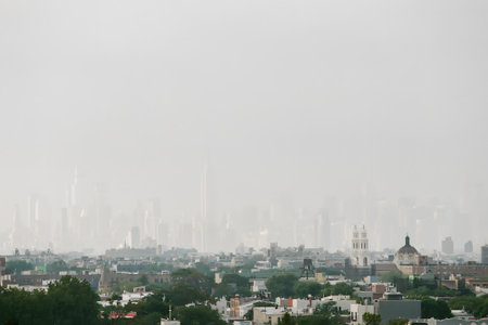 Looking over the city, fog blurs the skyline, shrouding buildings and creating a serene and mysterious view.の写真素材